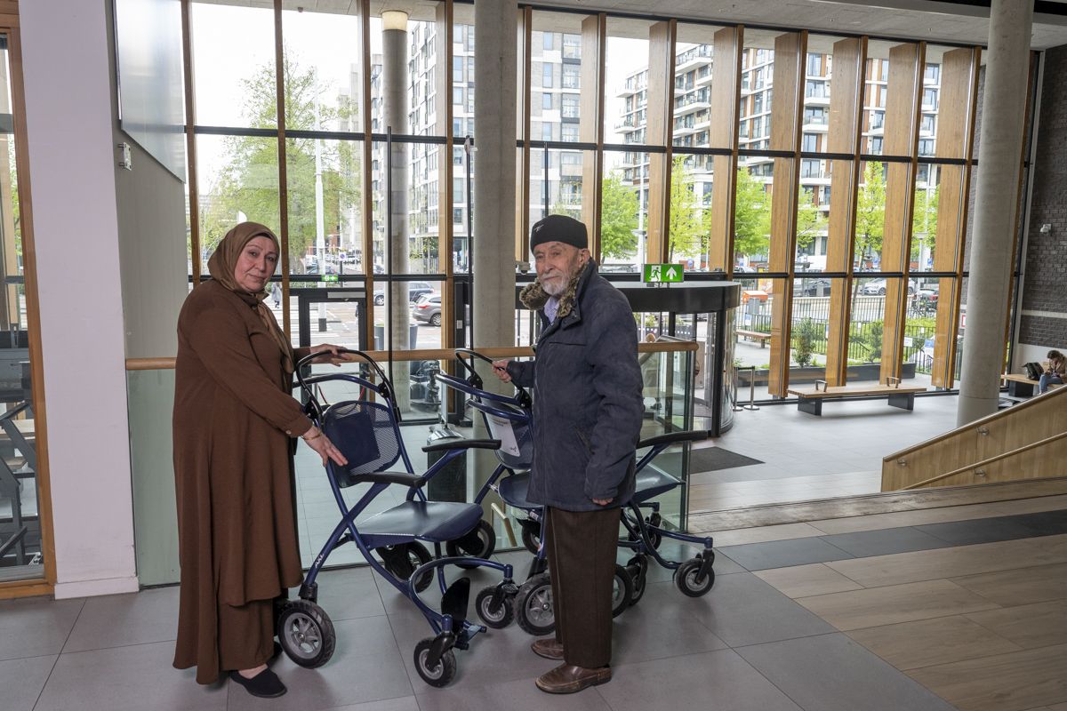 Patiënt en mantelzorger met rolstoel in de hal van OLVG West