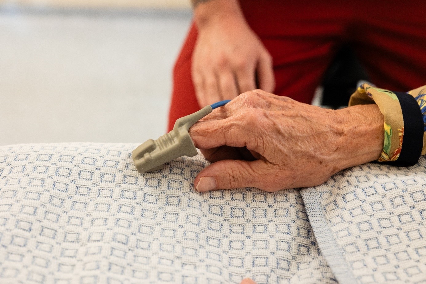 Hand van patënt met zorgverlener