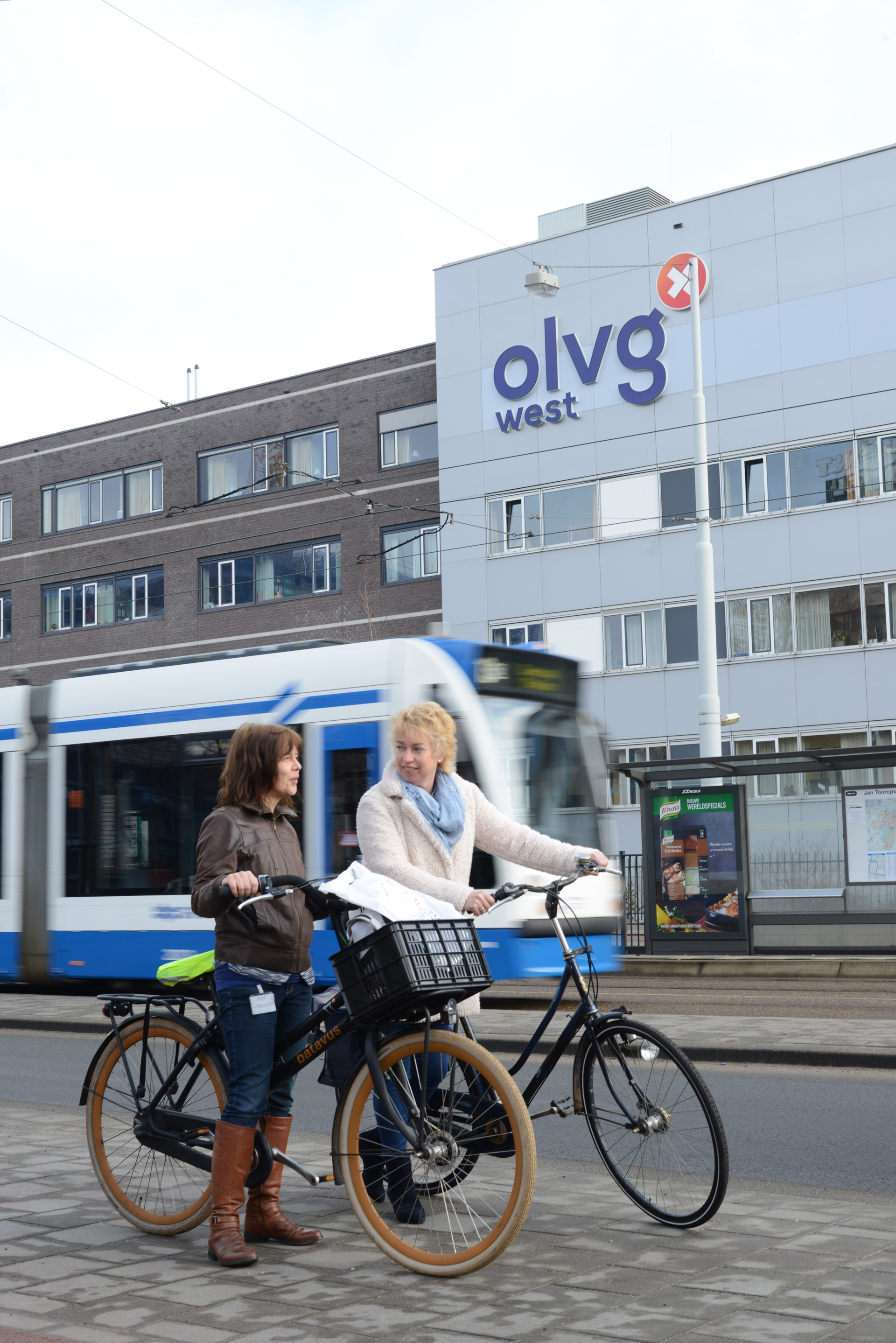 Twee vrouwen met hun fiets in de hand voor OLVG locatie West