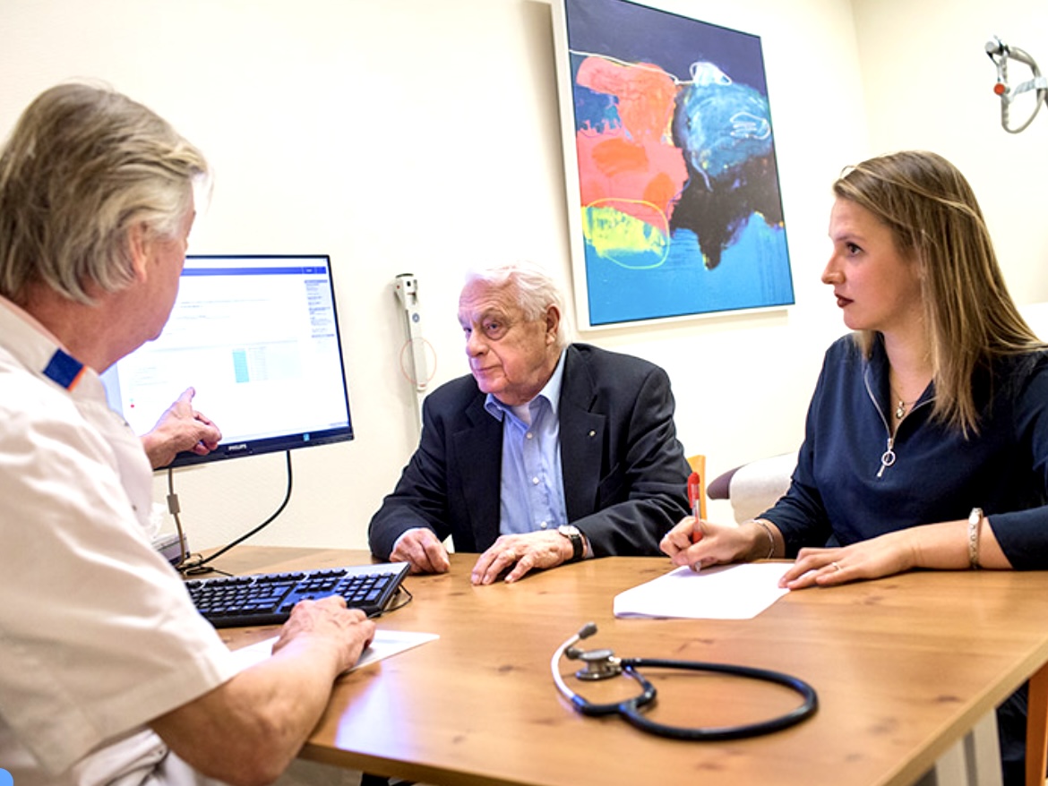 Arts en coassistent in gesprek met patiënt 