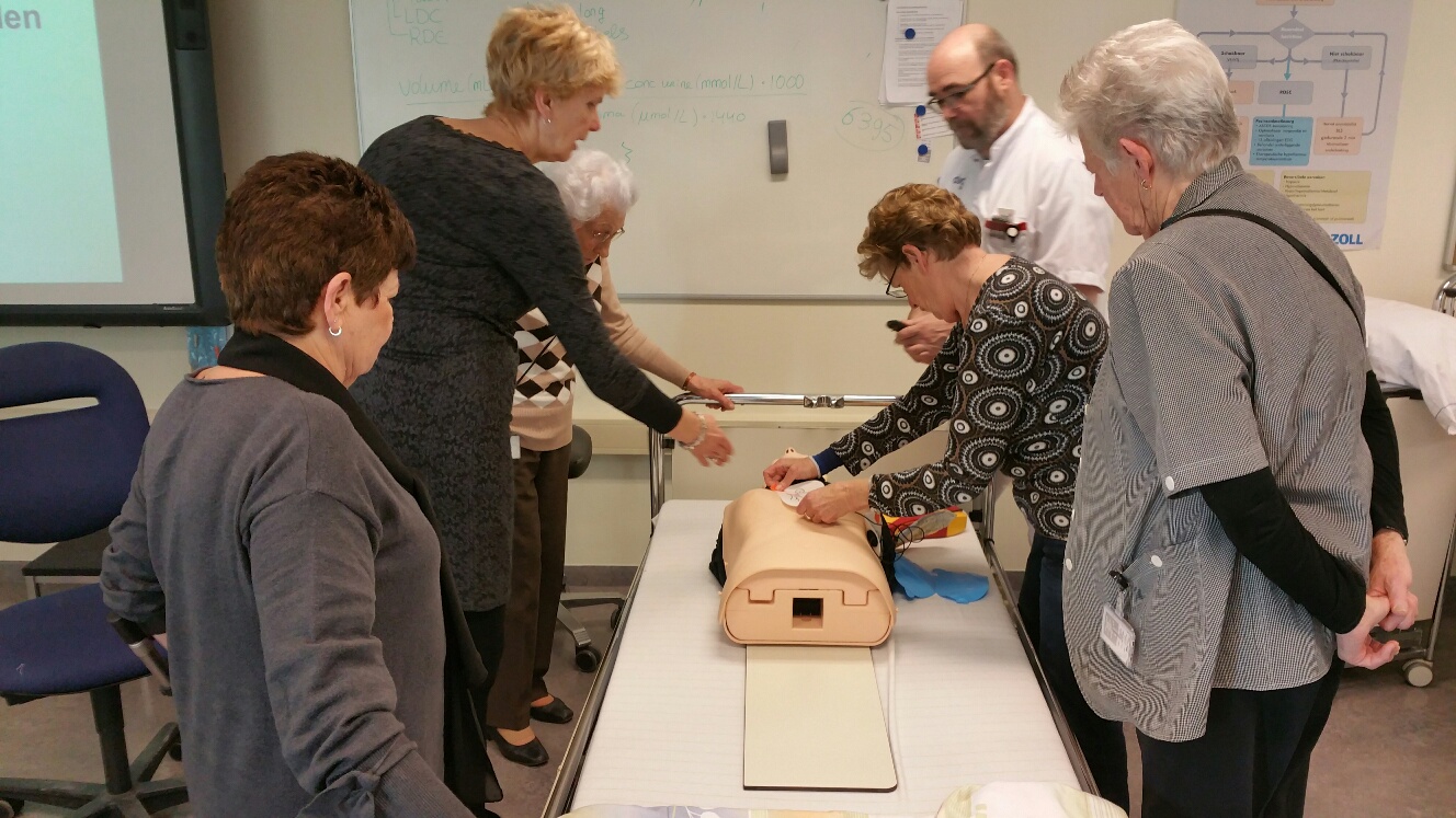 Vrijwilligers trainen op een reanimatiepop waar zij de AED-elektrodes moeten plakken