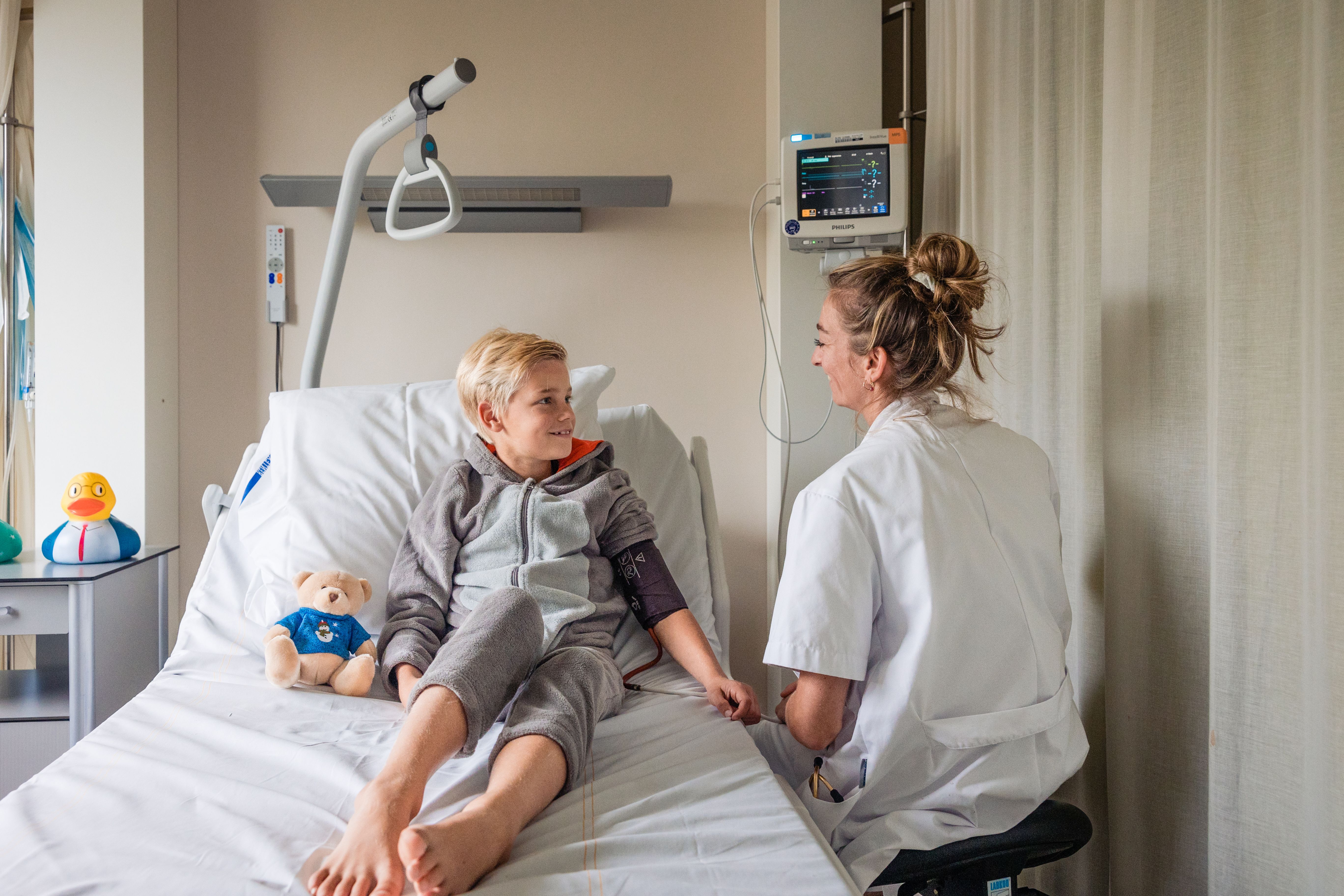 Bloeddrukmeting bij een jonge patiënt in ziekenhuisbed