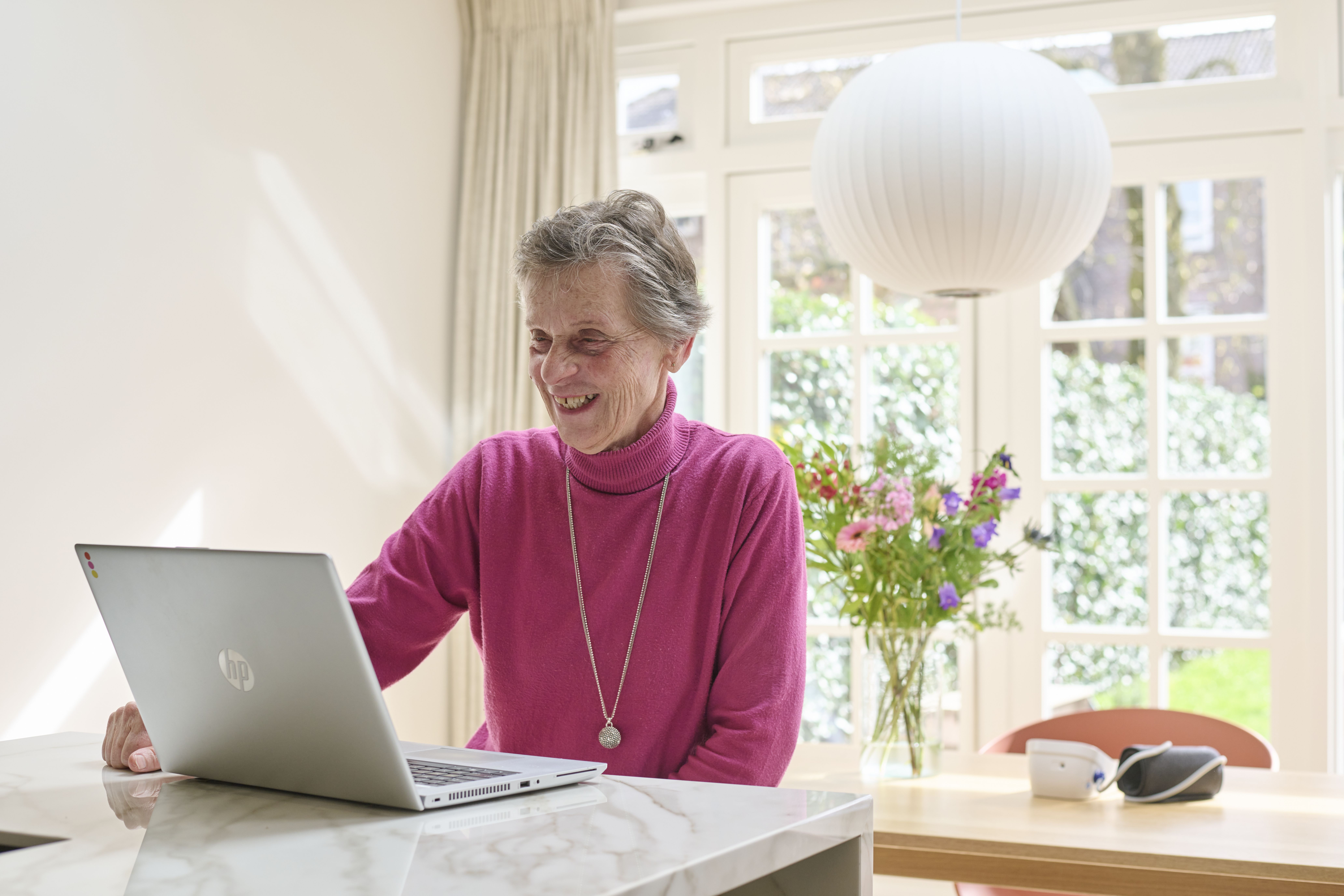 Foto van oudere patiënt met laptop